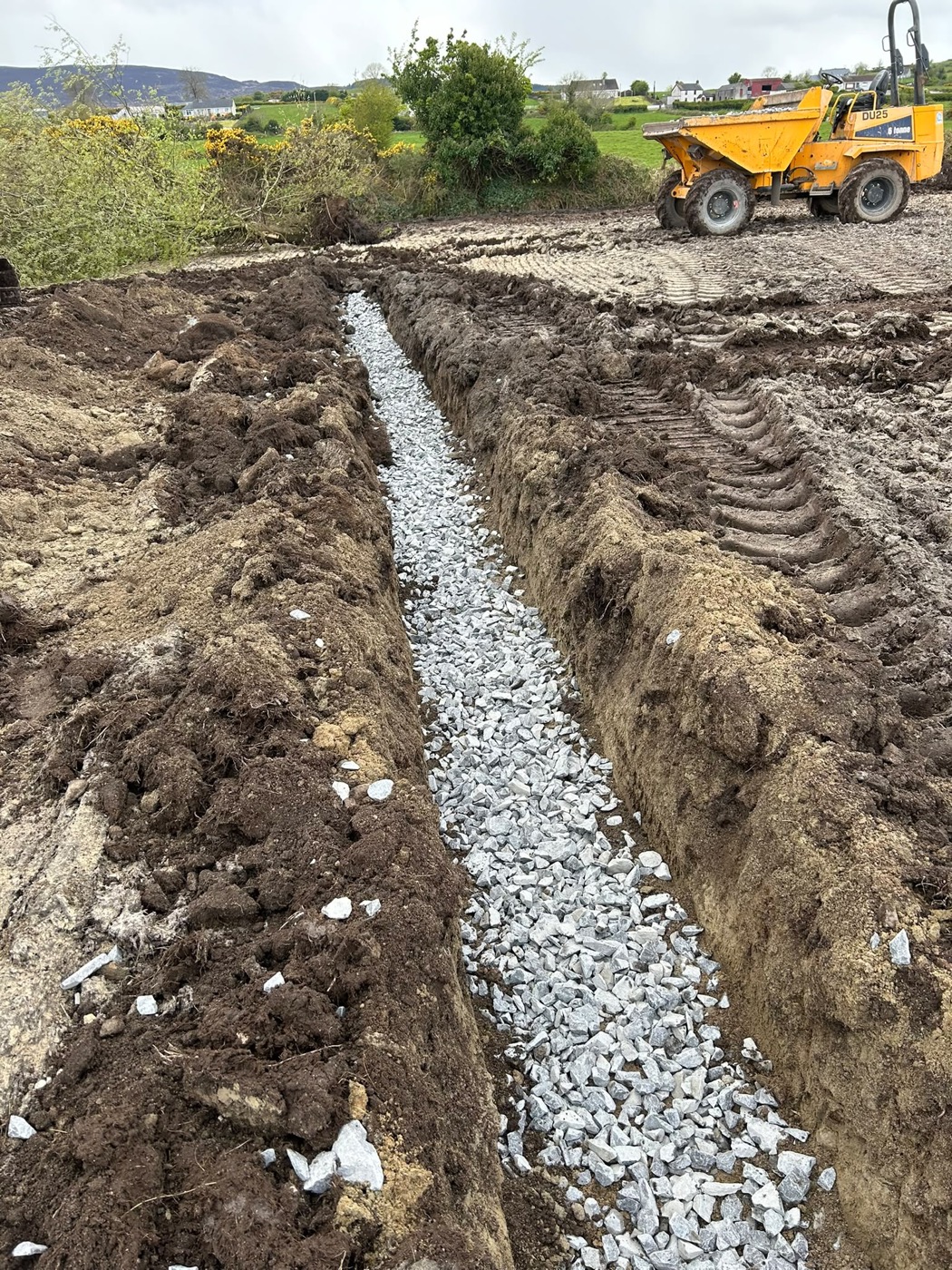 Land drainage trench with machinery on site